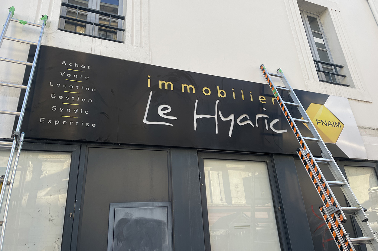 Installation d'une enseigne caisson bandeau pour l'agence immobilière Le Hyaric par Griffe Communication
