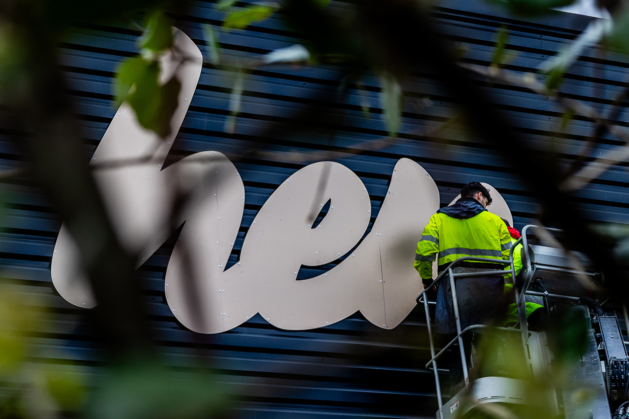 Lettrage découpé noir fixé sur bardage en bois, création de signalétique extérieure à Pau par Griffe Communication