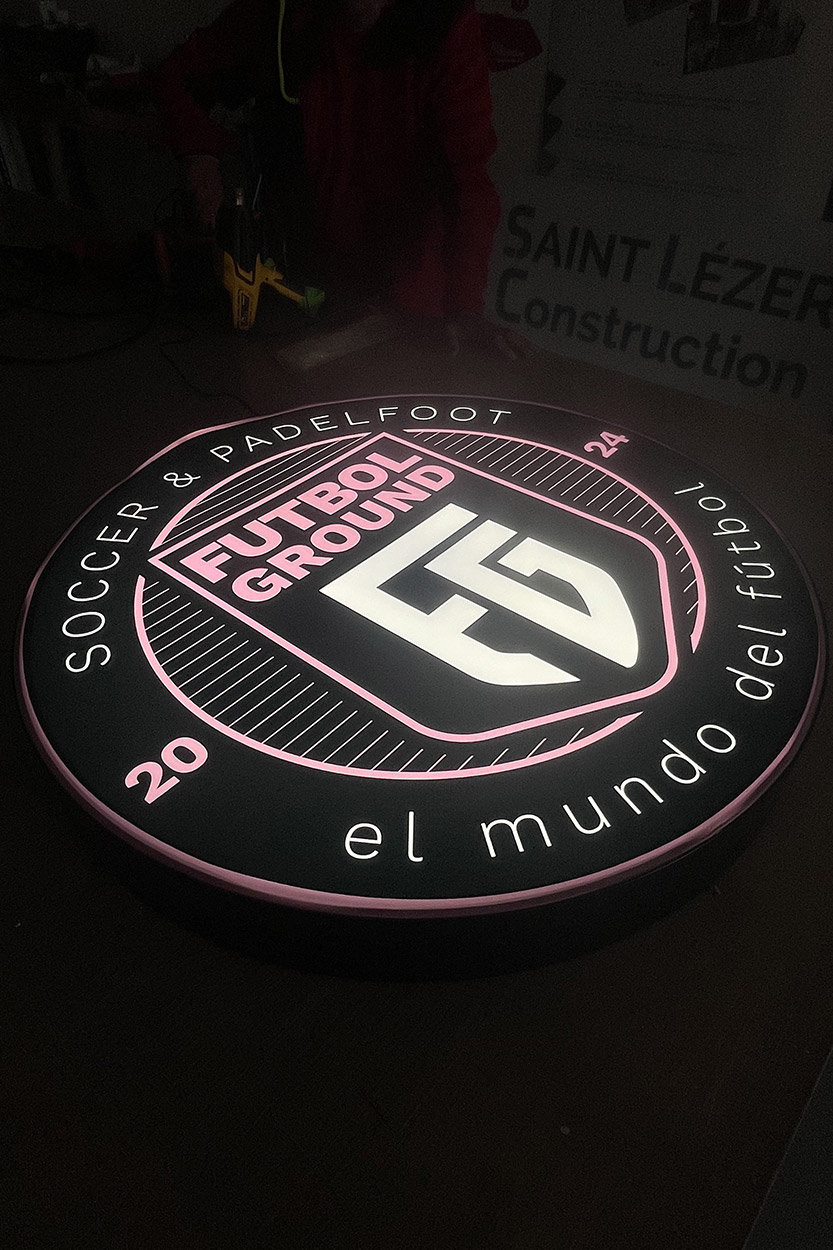 Enseigne lumineuse ronde Futbol Ground F5 avec façade en toile tendue rétro-éclairée, conception et réalisation de signalétique à Pau par Griffe Communication